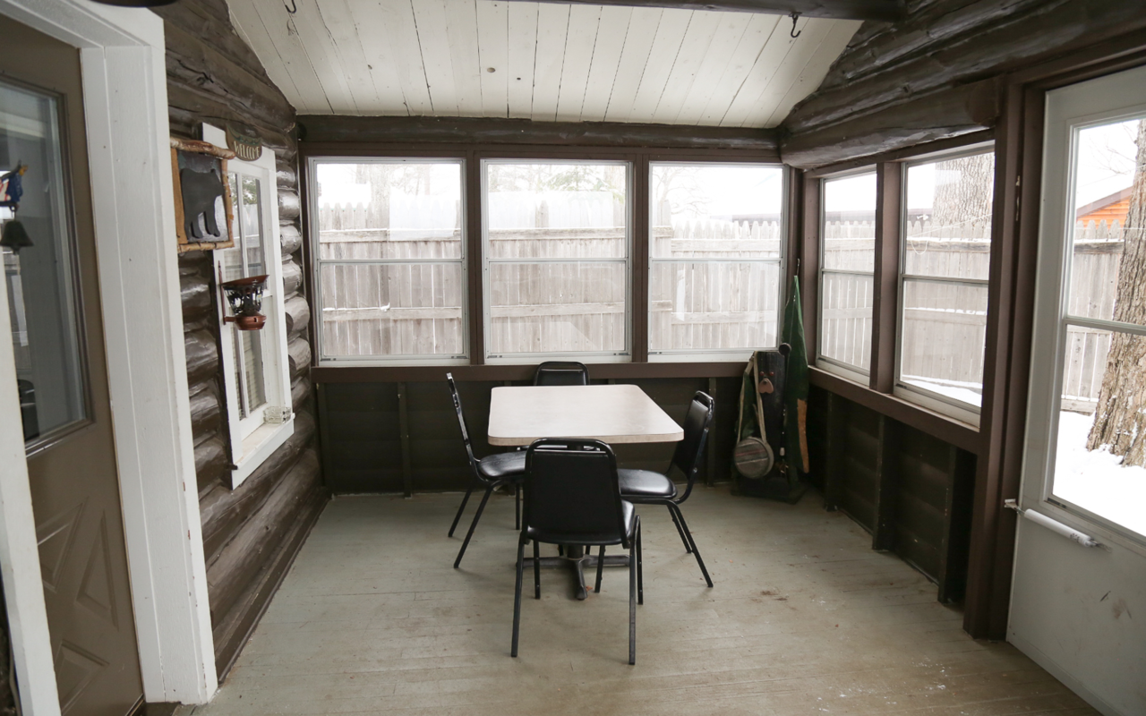 View of a screened in porch with small table and chairs.