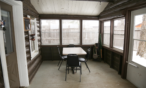 View of a screened in porch with small table and chairs.