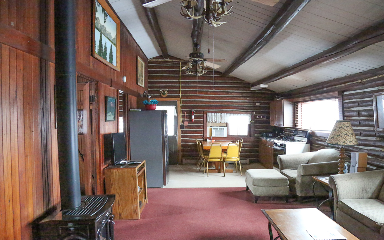 Interior cabin view of living room, kitchen and eating area.
