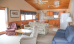 Interior cabin view of kitchen, eating area, and living room.