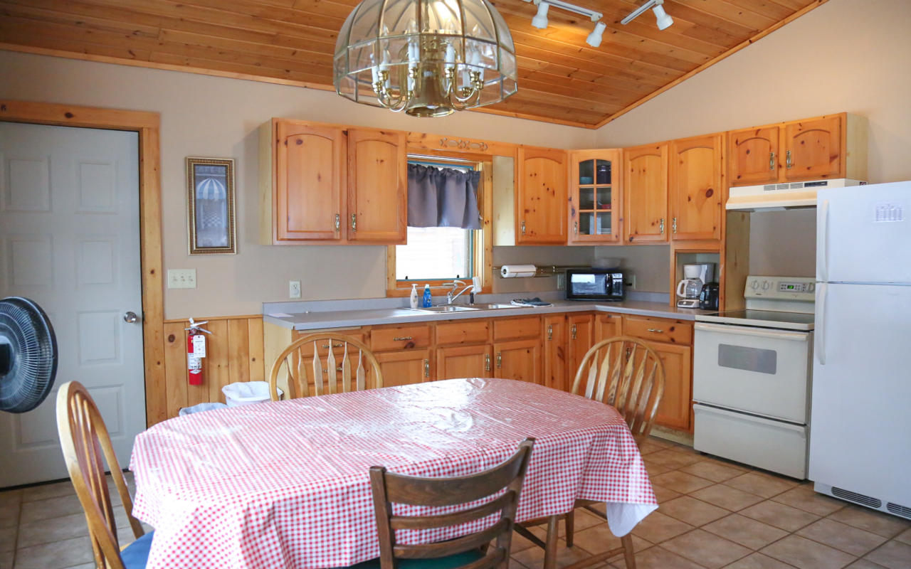 Interior cabin view of kitchen and eating areas.