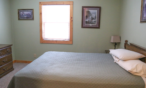 Interior cabin view of bedroom with queen bed.
