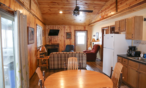 Interior long cabin view of sit in kitchen and living room space.