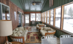 View of screened in porch with several seating areas.