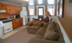Interior cabin view of kitchen, living room, and eating areas.