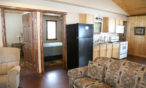 Cabin interior view of sitting area and kitchen.