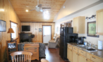 Long view of cabin interior of kitchen, and sitting area.
