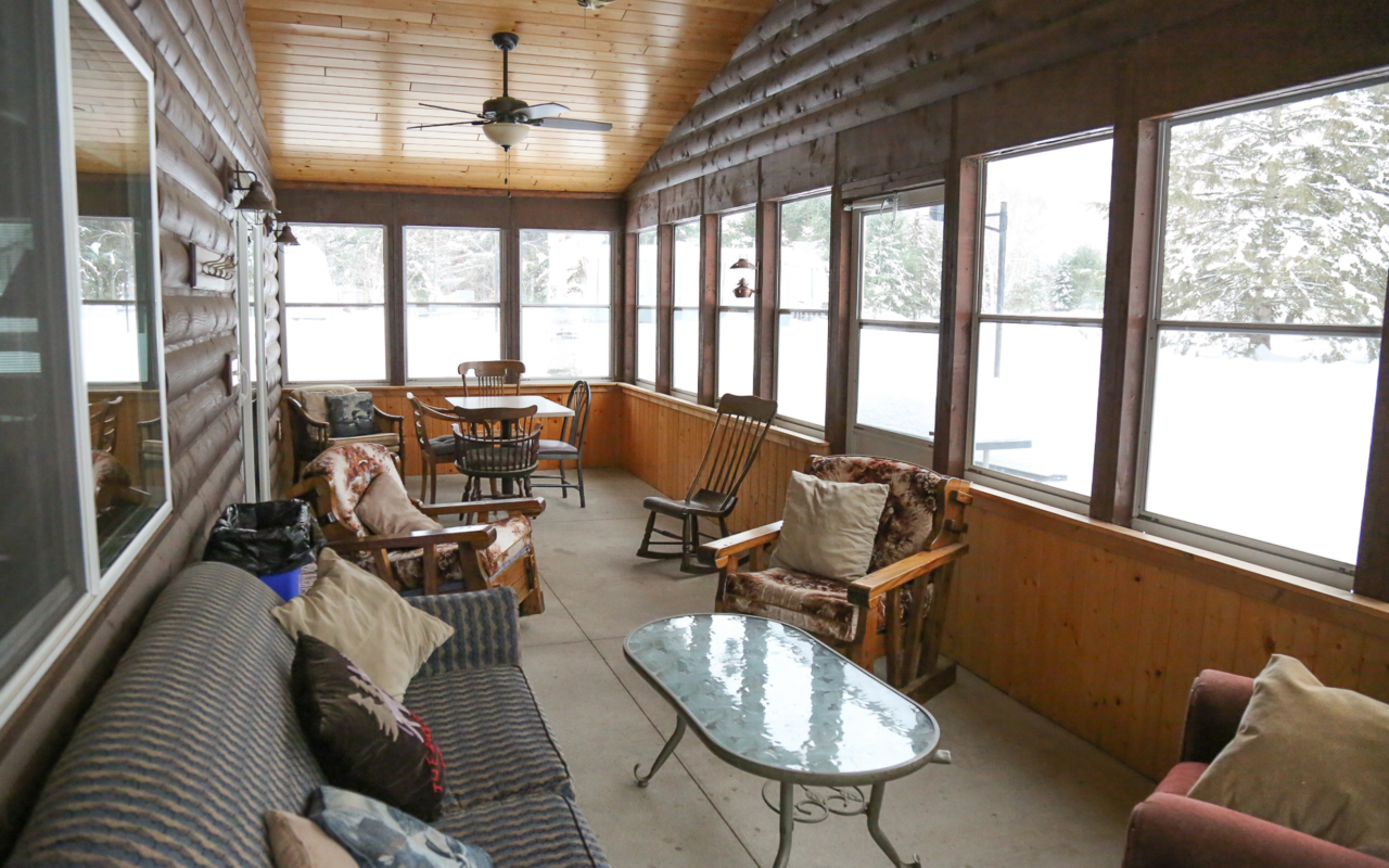 View of screened in porch with various seating areas.