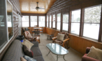 View of screened in porch with various seating areas.