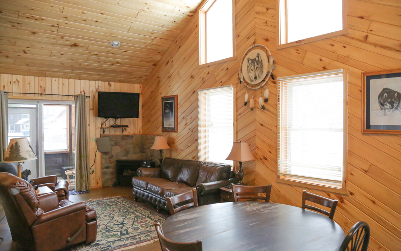Interior cabin image of dining table and living room.