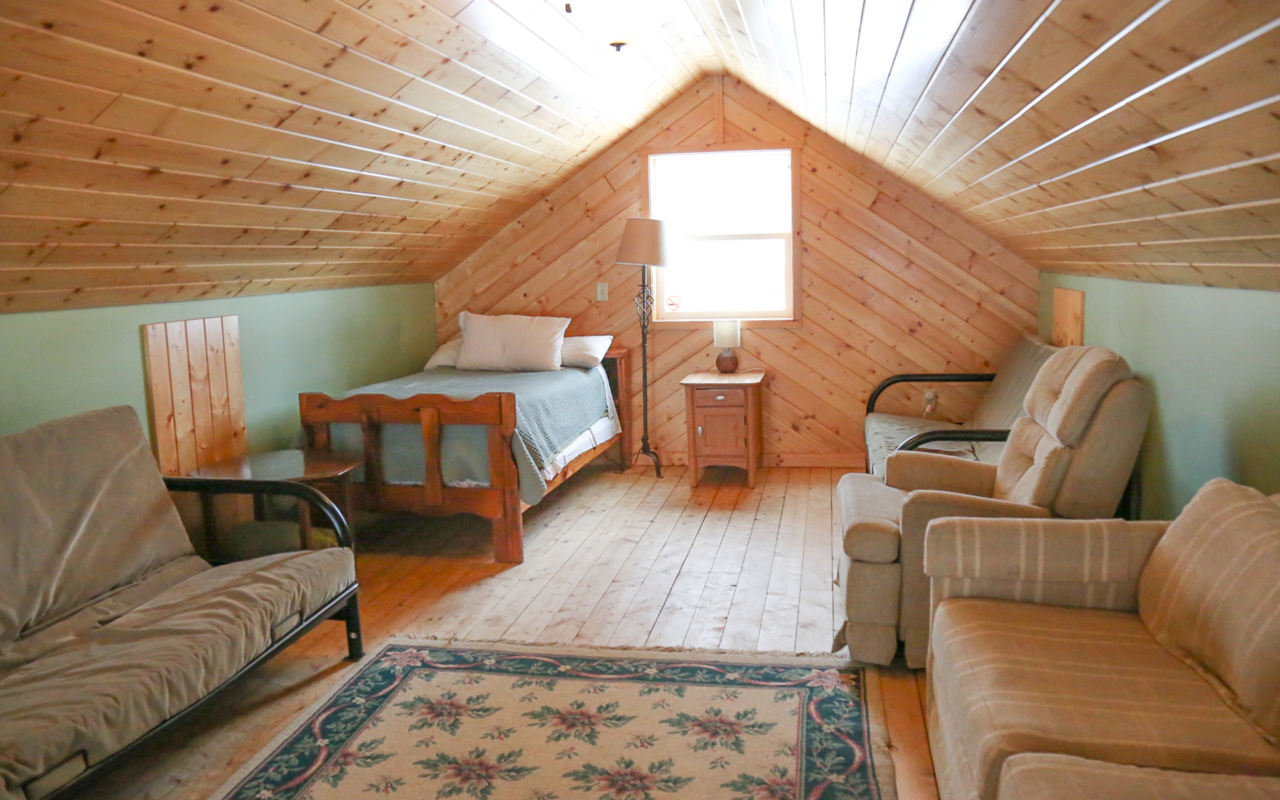 Interior cabin view of loft with twin bed and futon.
