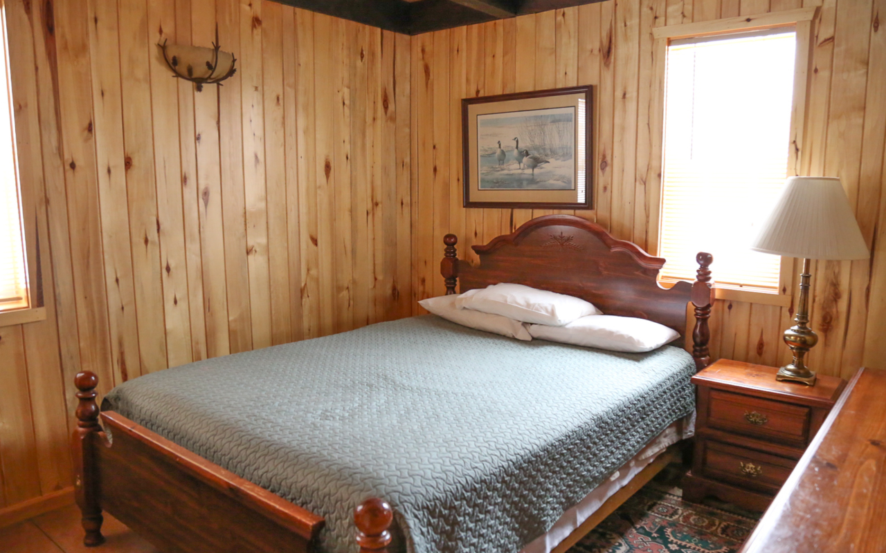 Interior cabin view of bedroom one with queen bed.