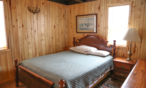 Interior cabin view of bedroom one with queen bed.